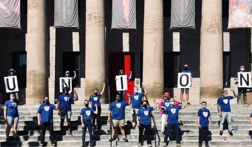 people spell union on the steps with signs