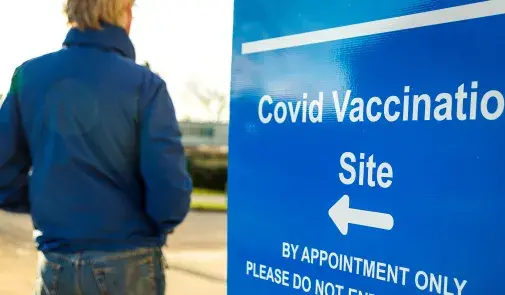 sign shows the direction to a covid vaccination site