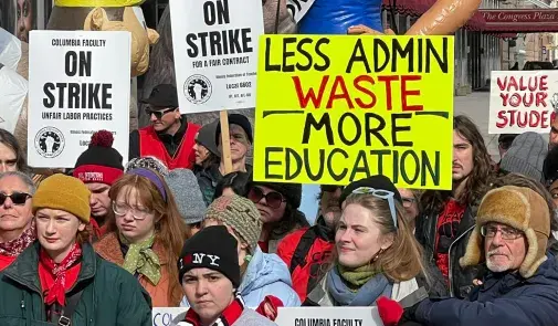 Photo of Columbia College Faculty Union members on the picket line. Signs read "Columbia Faculty On Strike. Unfair Labor Practices. Illinois Federation of Teachers, Local 6602. IFT, AFT, AFL-CIO", "Less Admin Waste, More Education", and "Value Your Students"