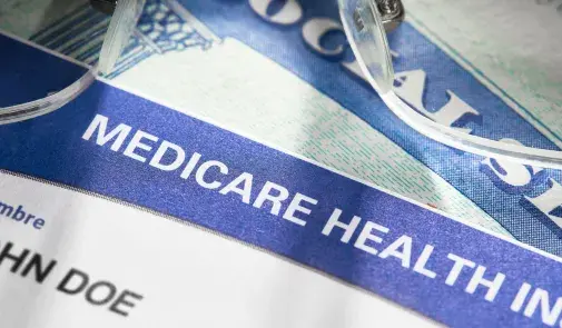 Photo of stacked documents. The top of a social security card is visible along with a medical insurance card.