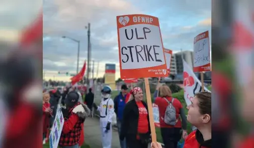 Photo of striking OFNHP workers. Sign reads "OFNHP - ULP Strike"