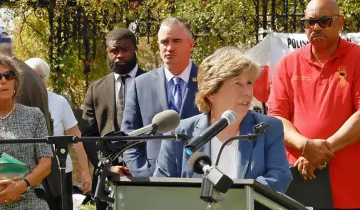 Photo of Randi Weingarten speaking at rally, surrounded by union officials