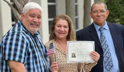 AFT member Mercedes Caceres, center, after her citizenship ceremony with HSEF President Iran Alicea, left, and Victor Moreno, also of HSEF, right. 