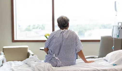 Getty Images hospital patient sitting on bed facing window