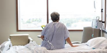 Getty Images hospital patient sitting on bed facing window