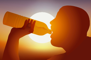 Photo of person drinking from a water bottle with the sun in the background