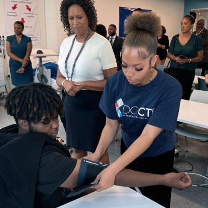 Washington, D.C. area students practice healthcare skills as the mayor looks on.