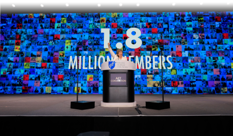 AFT membership has grown to 1.8 million members in 2024. Photo shows AFT President Randi Weingarten on stage with a graphic announcing 1.8 million members